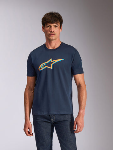 Alpinestars Ageless Shadow CSF Tee, T-shirt met korte mouwen, donkerblauw met oranje en lichtblauw schaduwlogo, gedragen door een model met donkere jeans, casual motorsport streetwear
